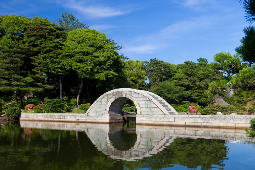 Brug over het water in de Shukkeien Japanse Tuin